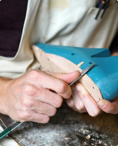 Foto monstrando um sapateiro trabalhando.